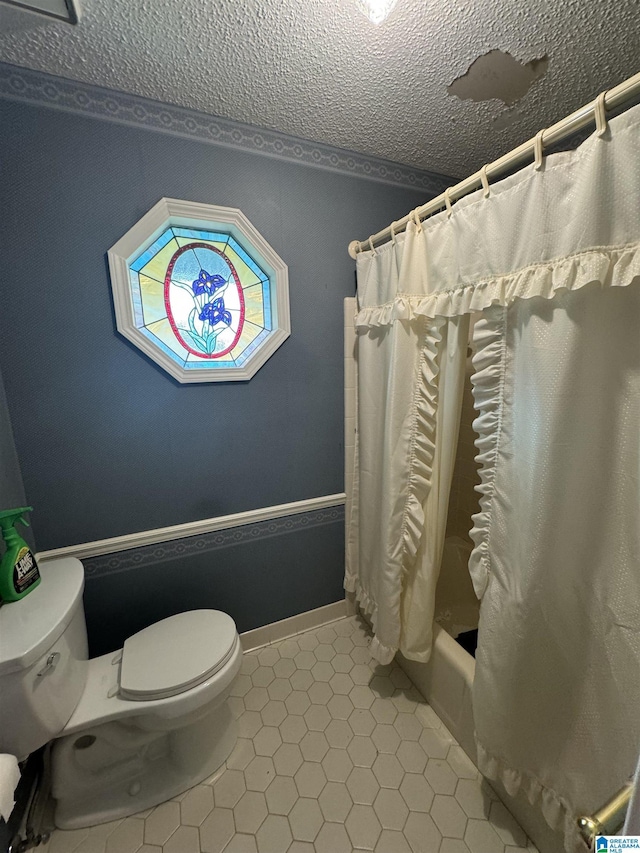 bathroom featuring toilet, tile patterned flooring, a textured ceiling, and shower / bath combo with shower curtain