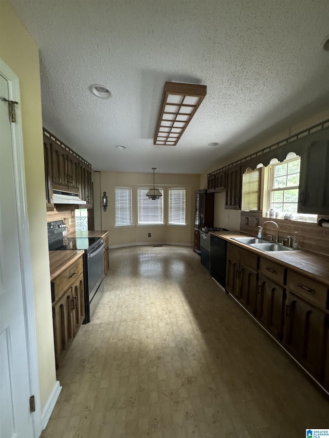 kitchen with a textured ceiling, sink, black appliances, wood counters, and dark brown cabinetry