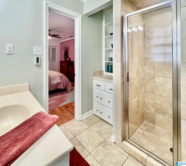 bathroom with tile patterned floors, ceiling fan, an enclosed shower, and vanity