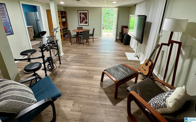 sitting room featuring light wood-type flooring and a wall of windows