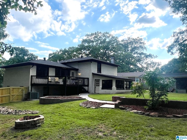 back of house with a fire pit, cooling unit, a wooden deck, and a lawn