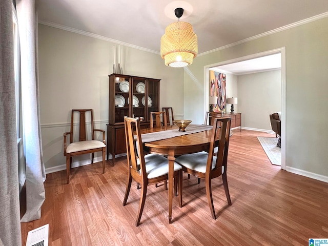 dining room featuring wood-type flooring and ornamental molding