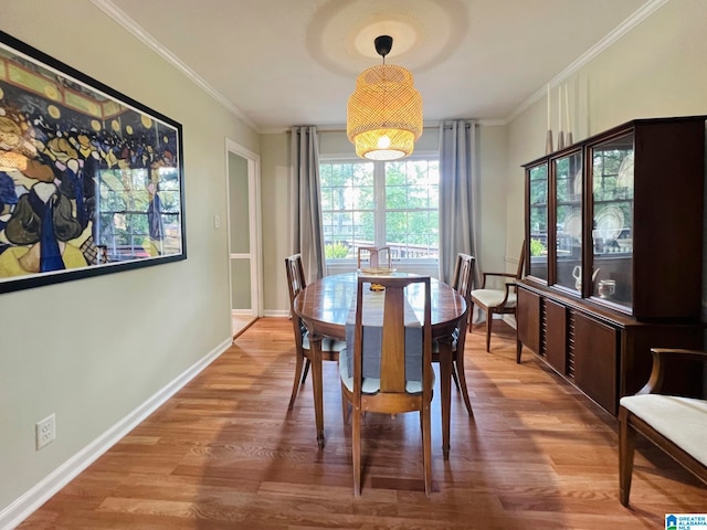 dining room with hardwood / wood-style flooring and crown molding