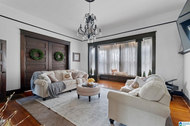 living room with hardwood / wood-style flooring and a notable chandelier