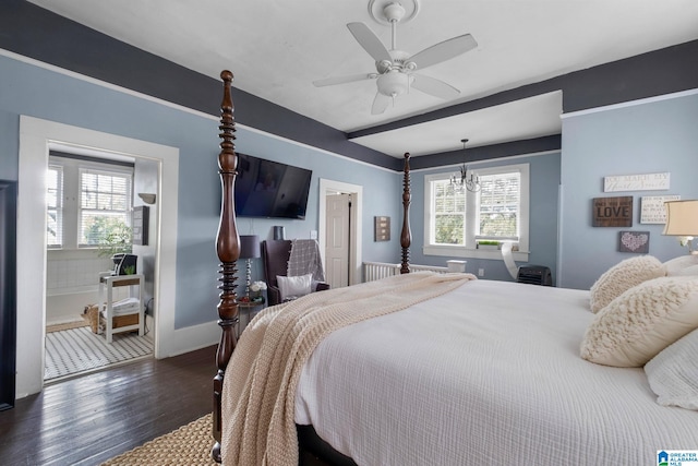 bedroom featuring dark wood-type flooring, ceiling fan with notable chandelier, and multiple windows