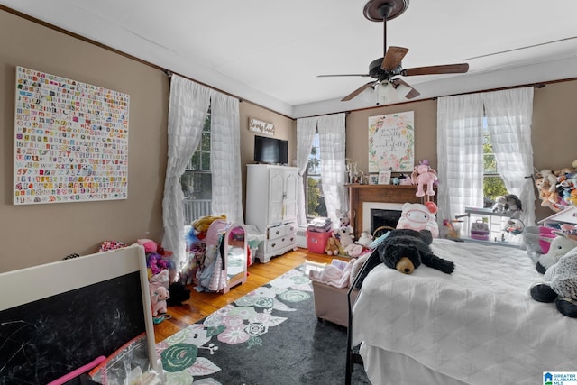 bedroom featuring crown molding, ceiling fan, and light wood-type flooring