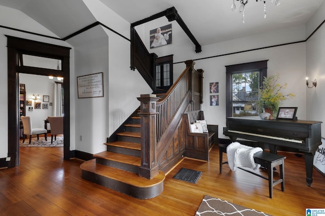 stairs featuring lofted ceiling and hardwood / wood-style floors