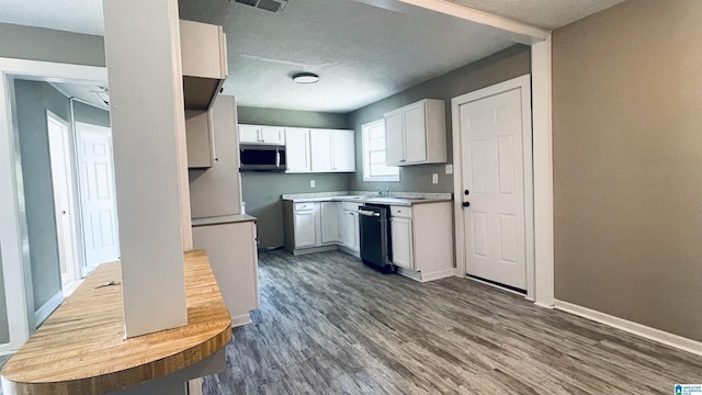 kitchen with white cabinetry, sink, dark wood-type flooring, and black dishwasher