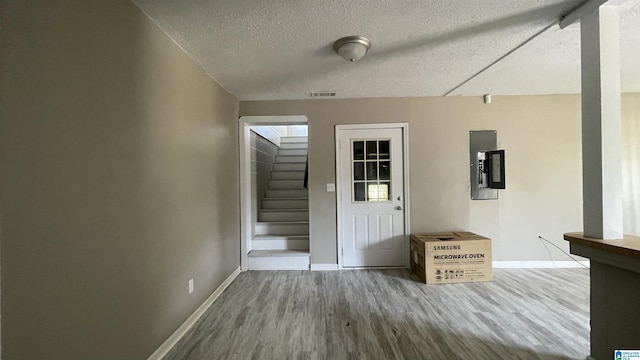 interior space with electric panel, hardwood / wood-style floors, and a textured ceiling