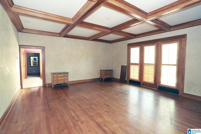 spare room with beam ceiling, coffered ceiling, and dark hardwood / wood-style floors