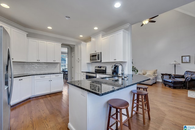 kitchen featuring dark stone countertops, sink, white cabinetry, and stainless steel appliances