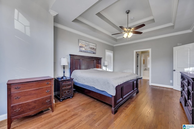 bedroom with a raised ceiling, ceiling fan, crown molding, and light wood-type flooring