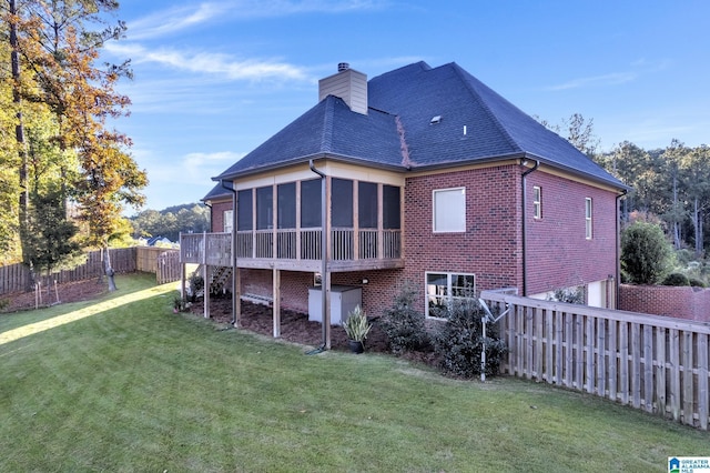 back of house featuring a yard and a sunroom