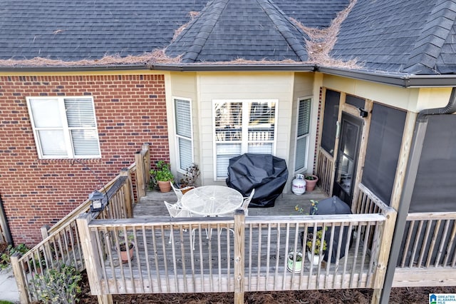 wooden terrace featuring a sunroom and a grill