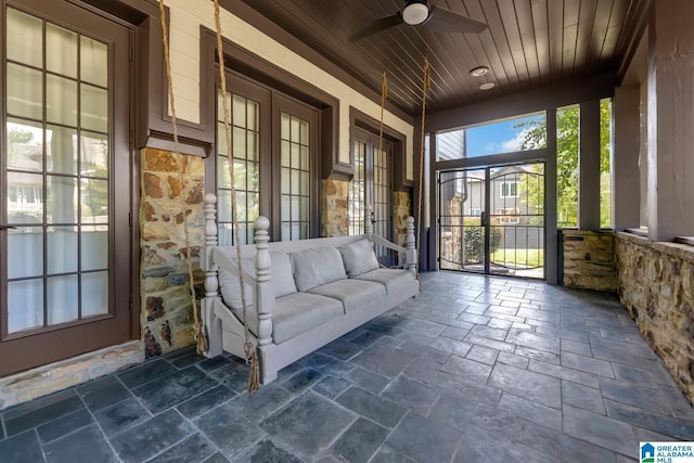 unfurnished sunroom featuring ceiling fan and wooden ceiling