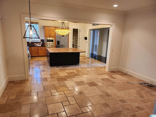 kitchen featuring backsplash, crown molding, appliances with stainless steel finishes, decorative light fixtures, and a kitchen island