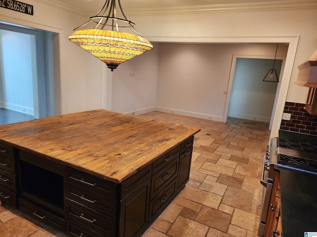 kitchen featuring stainless steel gas range, ornamental molding, tasteful backsplash, butcher block countertops, and a kitchen island