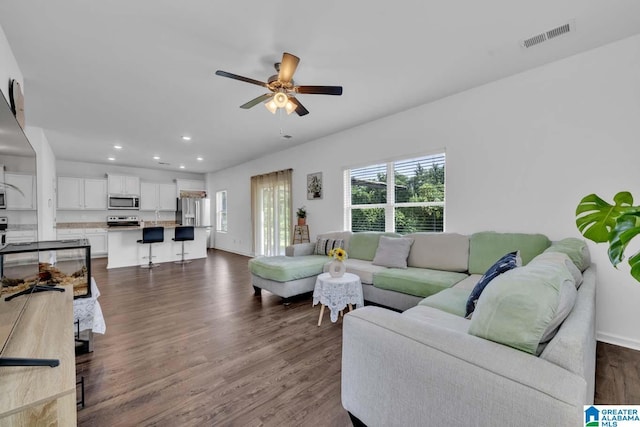 living room with ceiling fan and dark wood-type flooring