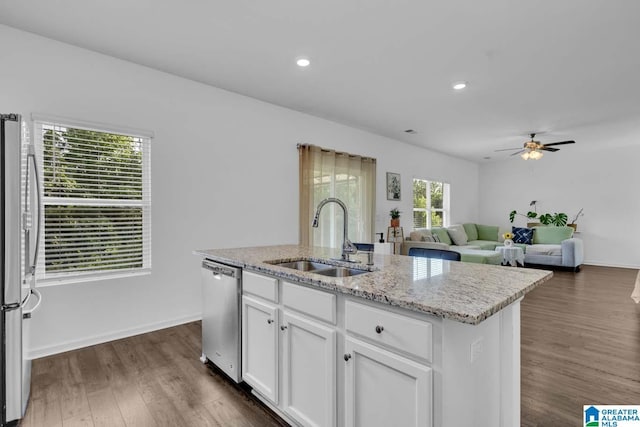 kitchen with appliances with stainless steel finishes, dark wood-type flooring, sink, white cabinetry, and an island with sink