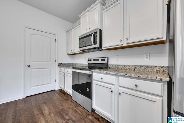 kitchen with white cabinetry, dark hardwood / wood-style flooring, light stone counters, and appliances with stainless steel finishes