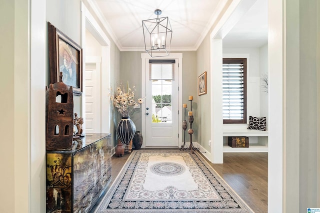 foyer entrance featuring wood-type flooring, crown molding, and a chandelier