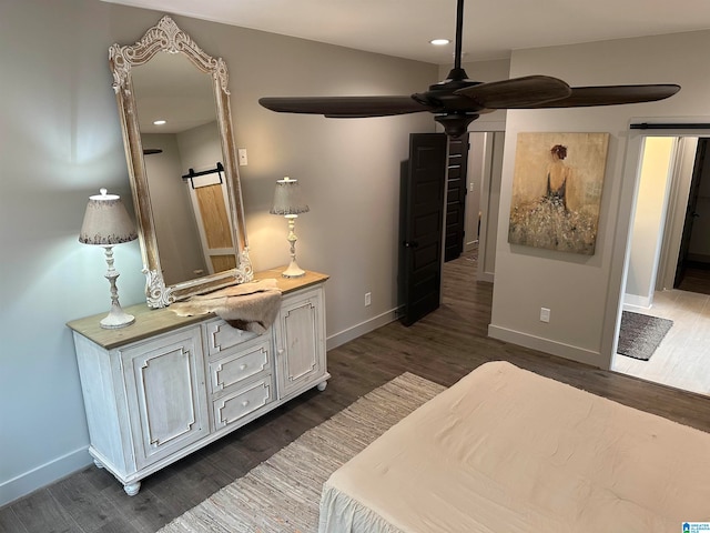 bedroom featuring dark wood-type flooring and a barn door