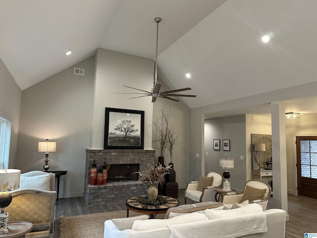 living room featuring a brick fireplace, vaulted ceiling, dark hardwood / wood-style floors, and ceiling fan