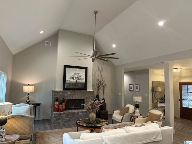 living room with ceiling fan, a brick fireplace, lofted ceiling, and dark hardwood / wood-style flooring