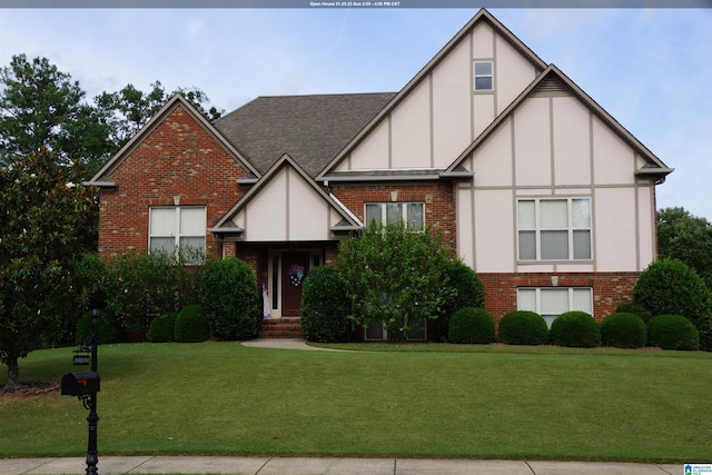 tudor-style house featuring a front yard