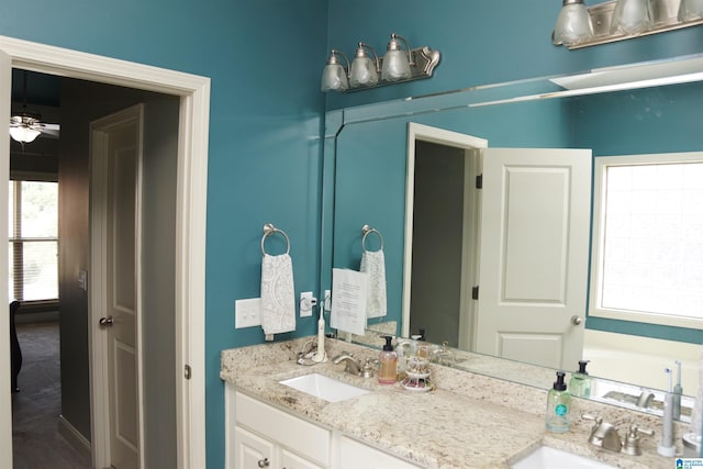 bathroom with vanity, ceiling fan, and a bathing tub