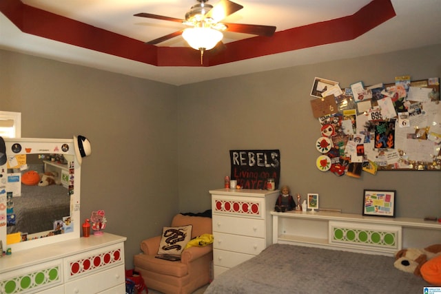 playroom featuring a tray ceiling and ceiling fan