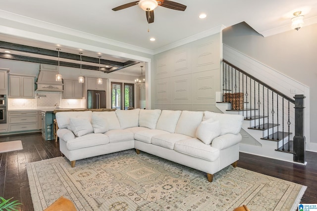 living room with beamed ceiling, dark hardwood / wood-style flooring, ornamental molding, and ceiling fan with notable chandelier