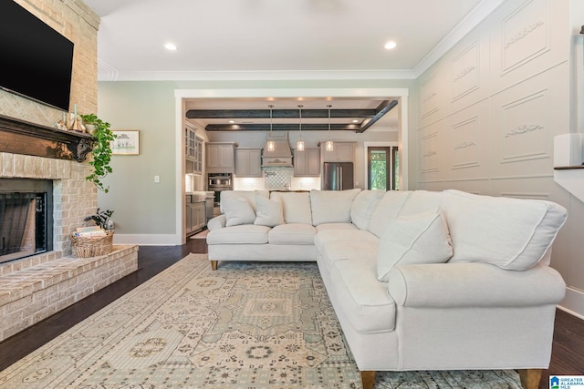 living room with crown molding, dark wood-type flooring, and a fireplace