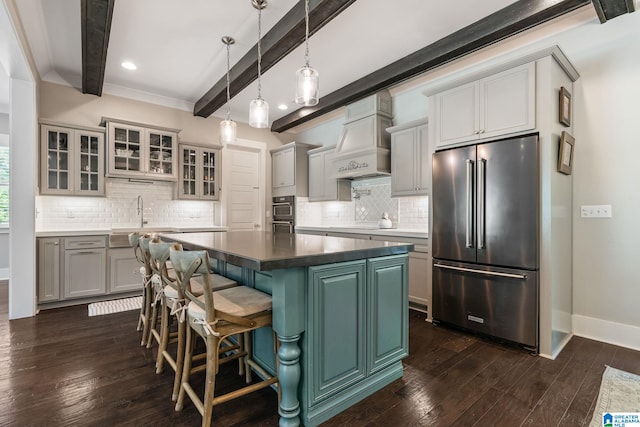 kitchen with dark hardwood / wood-style floors, beamed ceiling, stainless steel appliances, and custom range hood