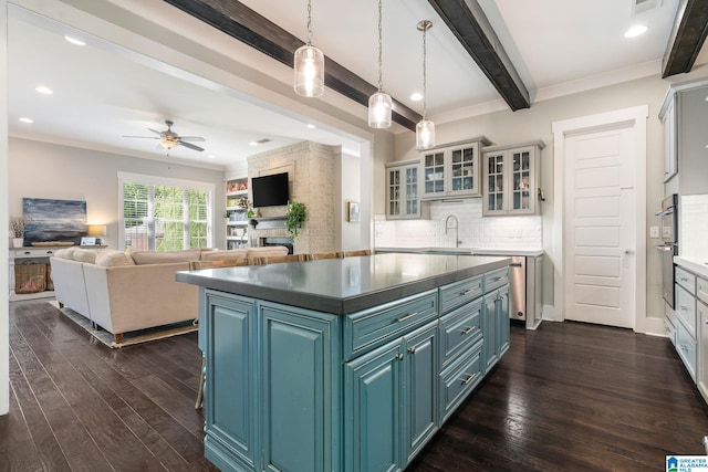 kitchen with ornamental molding, a kitchen island, dark hardwood / wood-style floors, tasteful backsplash, and ceiling fan