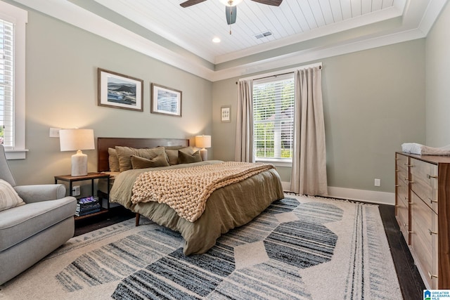 bedroom featuring a tray ceiling, ceiling fan, dark hardwood / wood-style floors, and crown molding