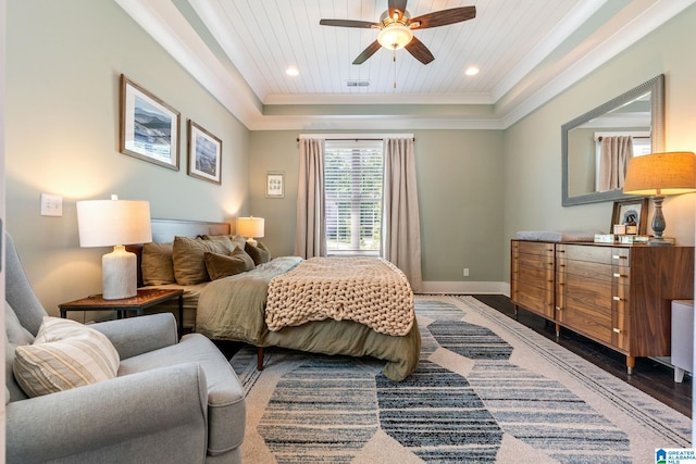 bedroom featuring ceiling fan, a tray ceiling, crown molding, and wood-type flooring