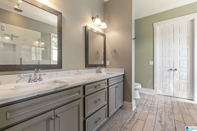 bathroom featuring double sink vanity, hardwood / wood-style flooring, and toilet