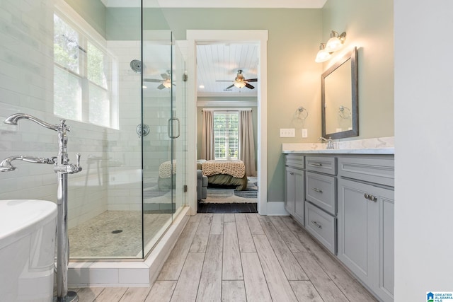 bathroom featuring a shower with shower door, wood-type flooring, vanity, and ceiling fan