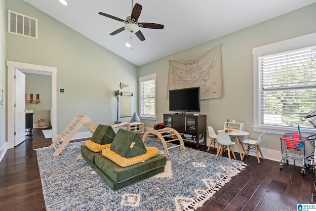 living room featuring a wealth of natural light, lofted ceiling, ceiling fan, and dark hardwood / wood-style flooring