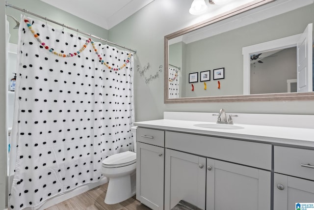 full bathroom with shower / bathtub combination with curtain, large vanity, ceiling fan, and toilet