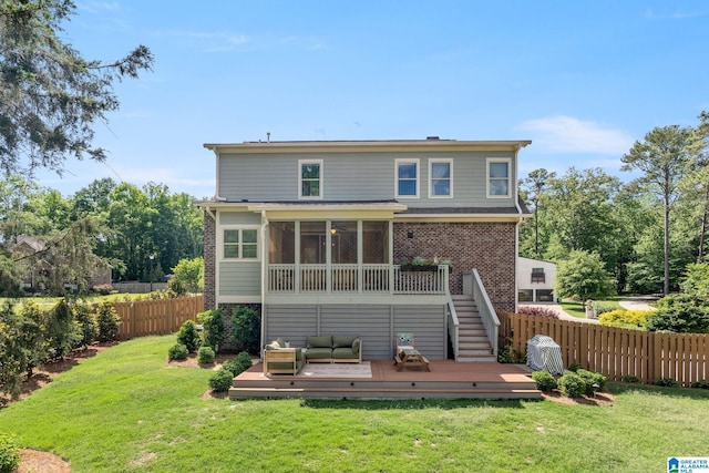 rear view of house featuring a sunroom, a yard, and a wooden deck