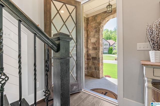 entrance foyer featuring ornamental molding and dark wood-type flooring