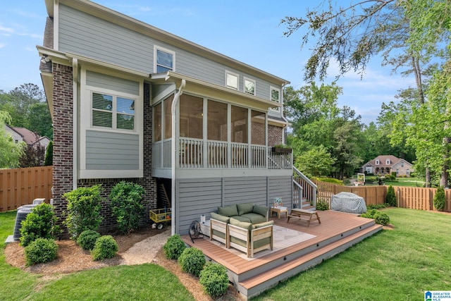 back of property with a sunroom, outdoor lounge area, a lawn, and a wooden deck