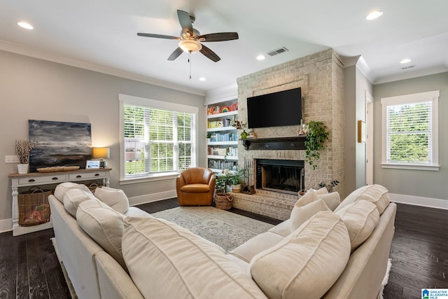 living room featuring a healthy amount of sunlight, a brick fireplace, dark hardwood / wood-style flooring, and ceiling fan