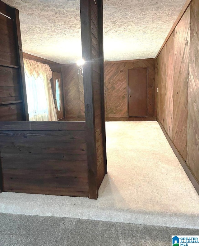 hall featuring light colored carpet and wood walls