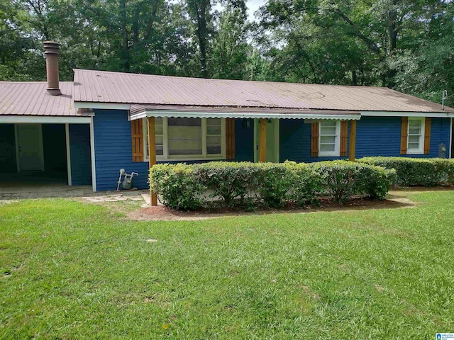 single story home with an attached carport, metal roof, and a front yard