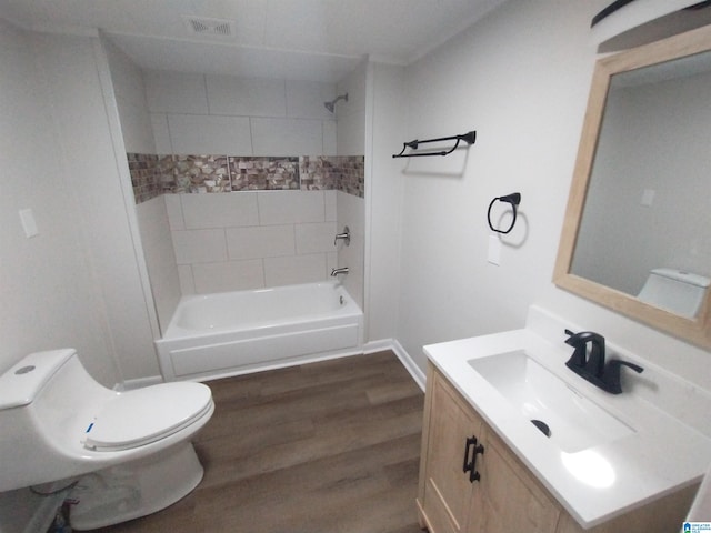 full bathroom featuring tiled shower / bath combo, oversized vanity, toilet, and hardwood / wood-style floors