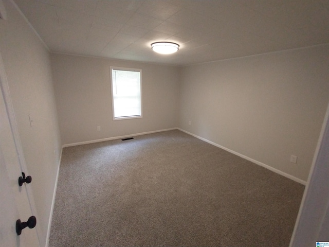 carpeted empty room featuring baseboards and visible vents