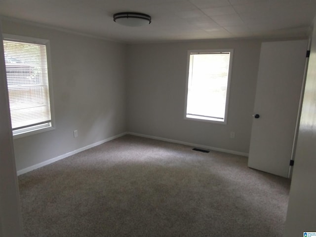 carpeted empty room featuring visible vents and baseboards